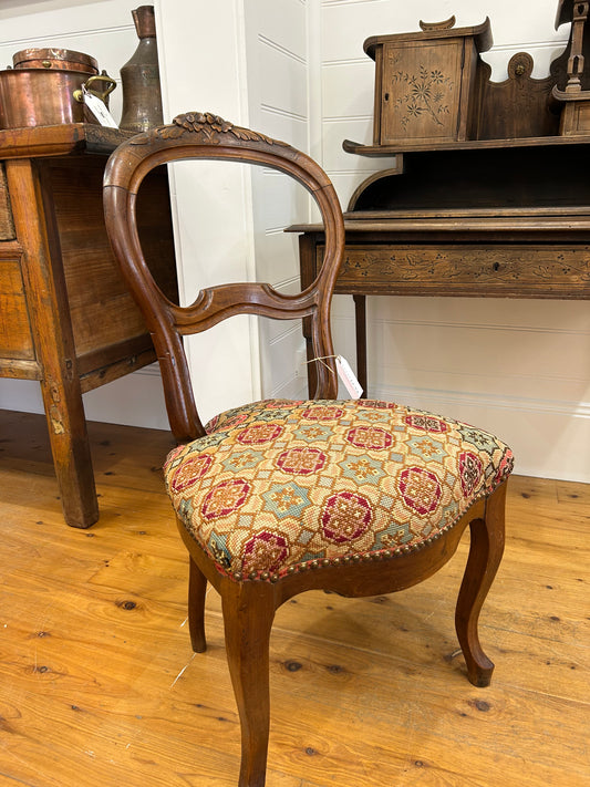 Lovely antique French salon chair with cross stitch upholstery and overly carving on the backrest from Provence