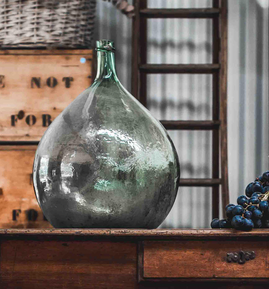 A gorgeous large green demijohn blown glass wine makers bottle, from Provence