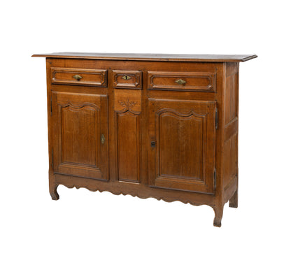 A charming 19th century antique French oak sideboard with brass hardware and some lovely timber carvings found in a grocery shop, in the French Alps.